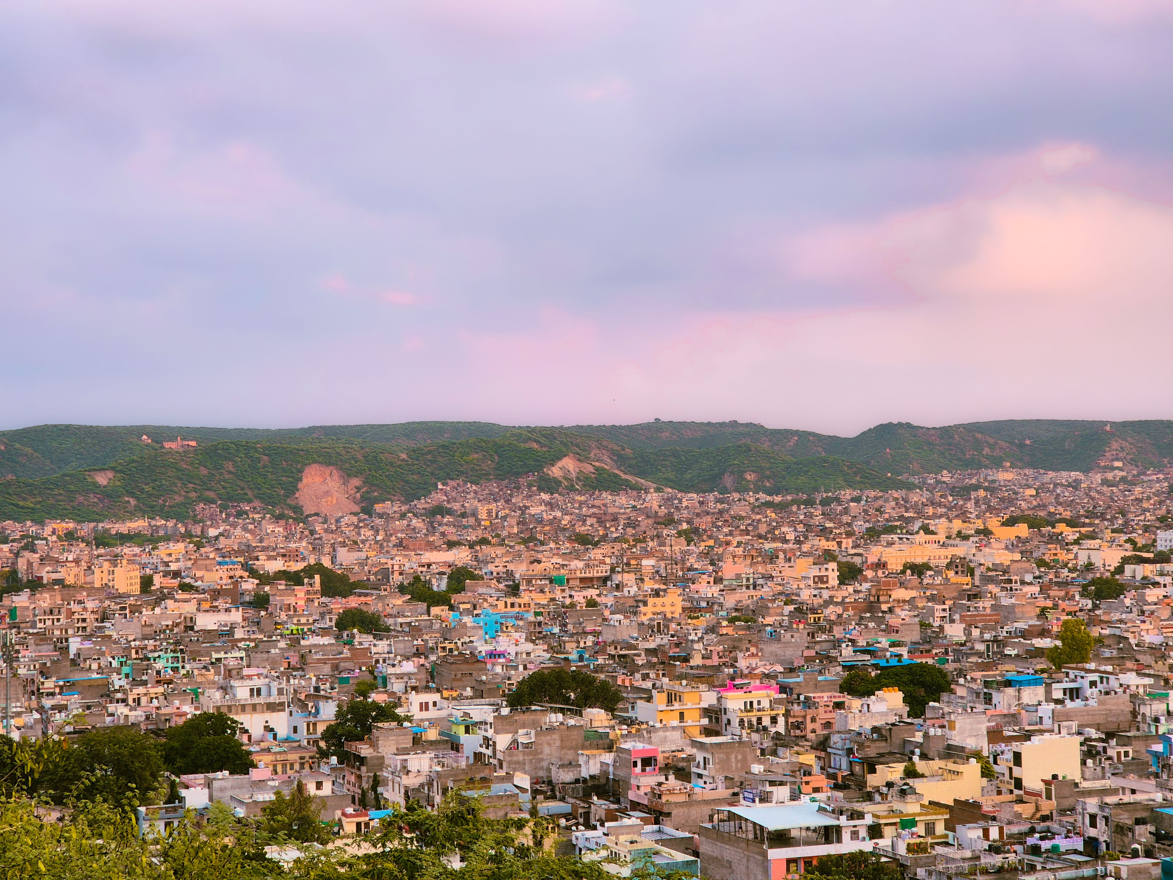 Jaipur seen from above at dusk, with the Aravalli hills behind