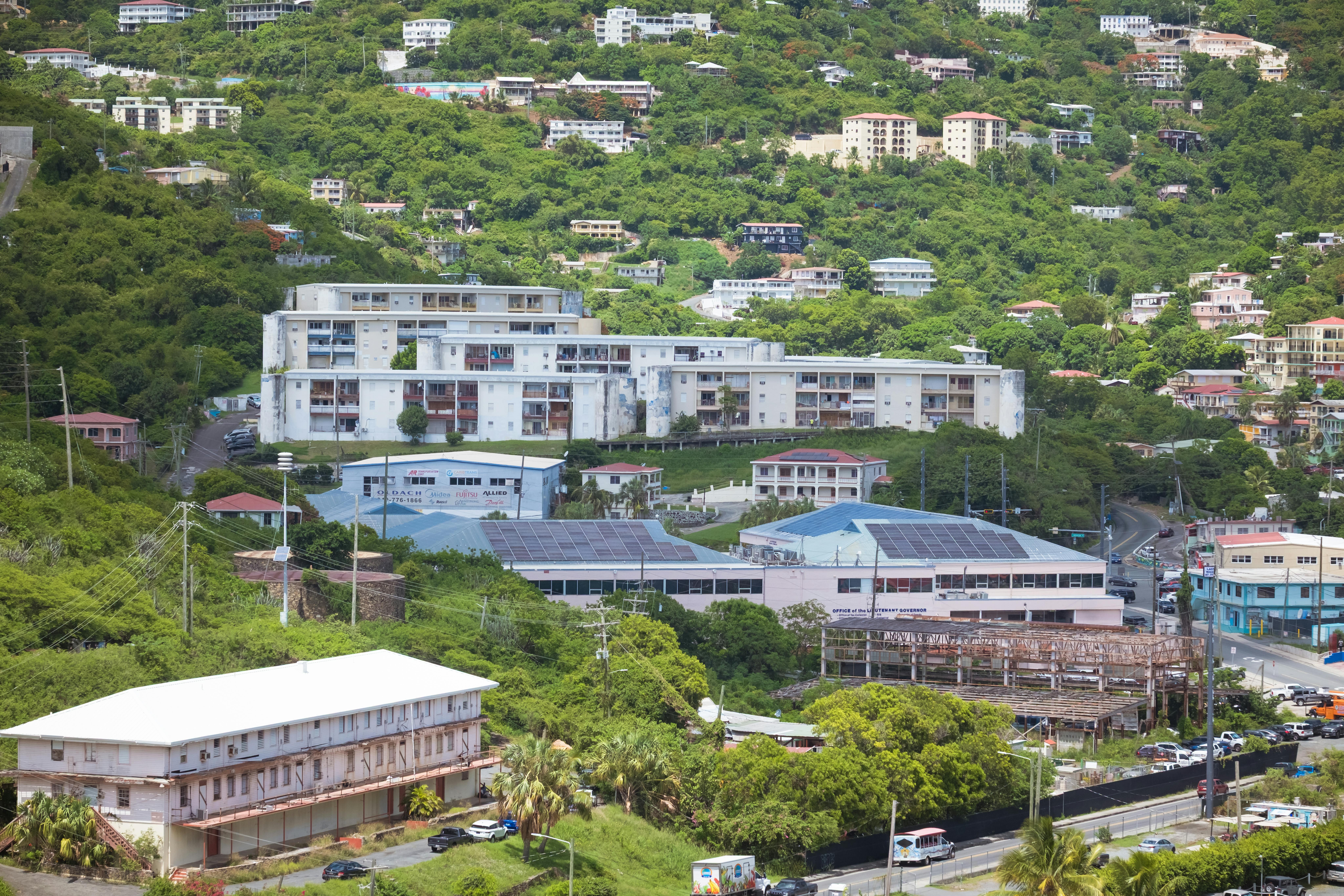 Aerial view showcasing buildings nestled in lush greenery, capturing urban life amidst nature.