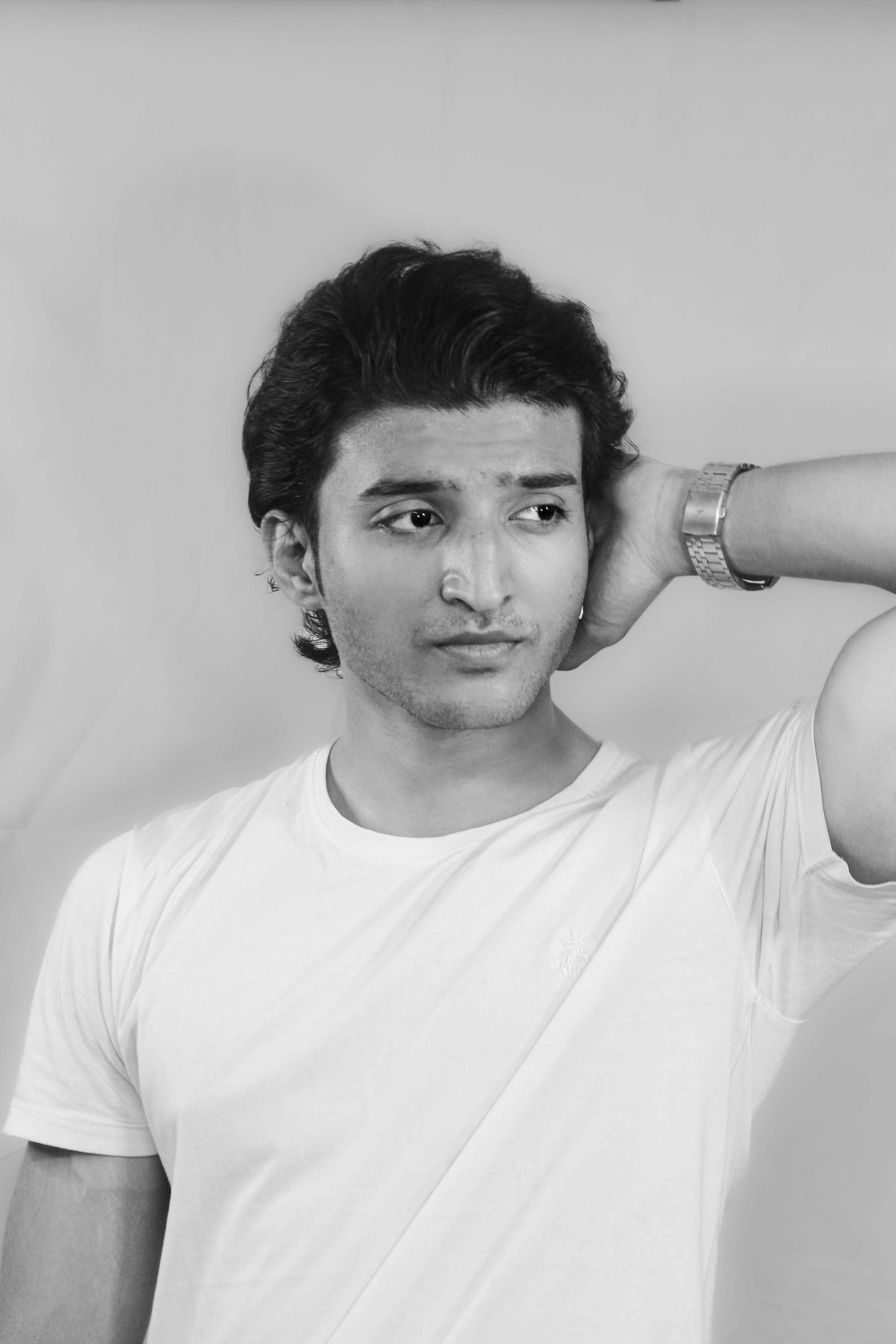 Monochrome portrait of a young man in a casual pose, exuding confidence and style.