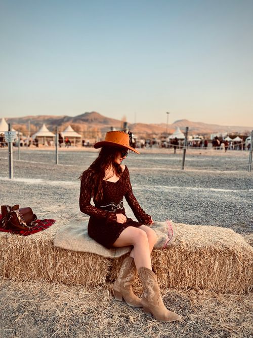 Free Stylish cowgirl at outdoor festival in rustic hayfield setting. Stock Photo
