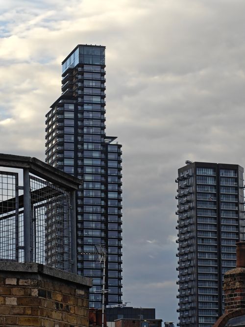 Free Contemporary skyscrapers with glass facades set against a moody, cloudy sky. Stock Photo
