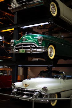 Vintage cars on a multi-level display indoors, highlighting classic automotive design.