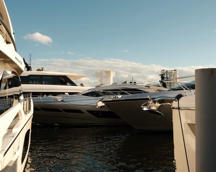 A stunning view of several luxury yachts anchored at a marina on a sunny day.