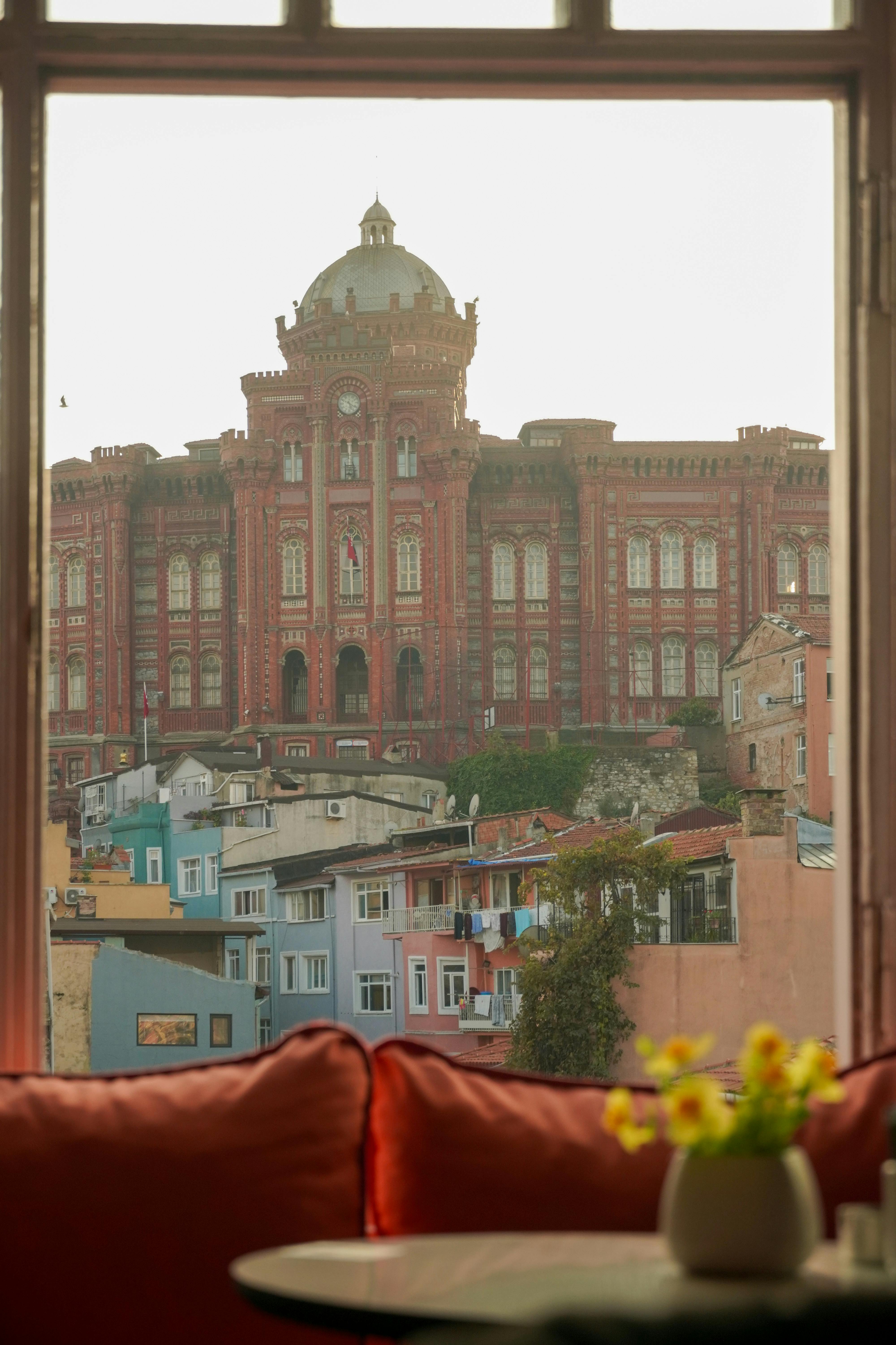 View of historic Istanbul's colorful architecture from a cozy cafe window.