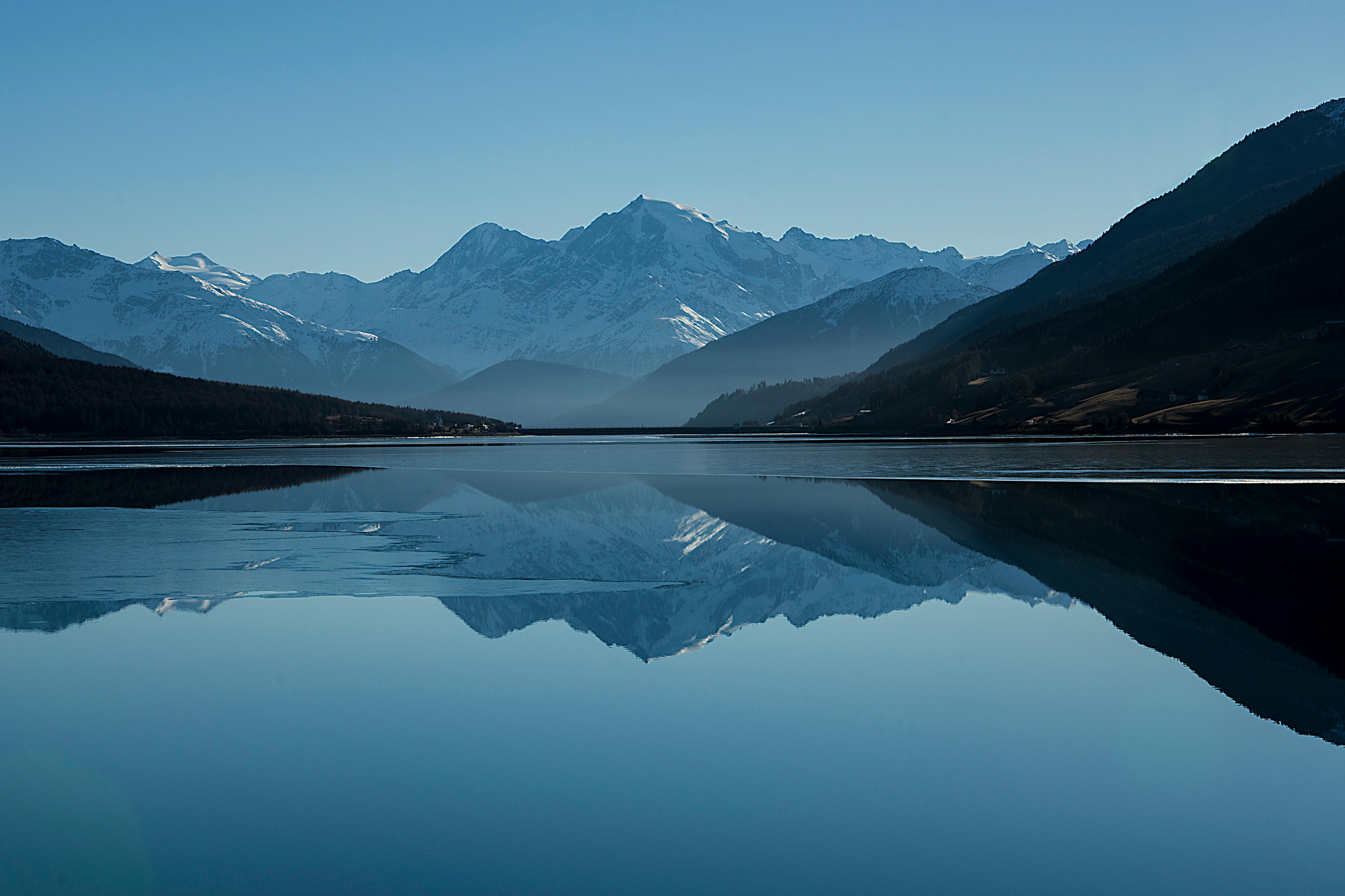 calm body of lake between mountains