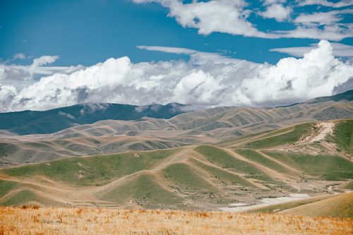 Free Expansive landscape with rolling hills under a vibrant, cloud-streaked sky. Stock Photo