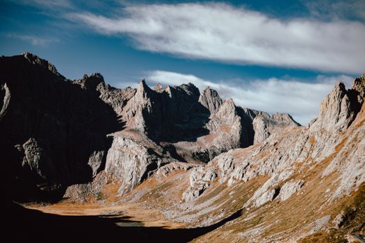 Dramatic mountain landscape with rugged peaks under a bright blue sky, perfect for adventure and travel themes.