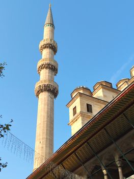 Stunning view of a historic mosque minaret in Istanbul, Turkey, under a clear blue sky.