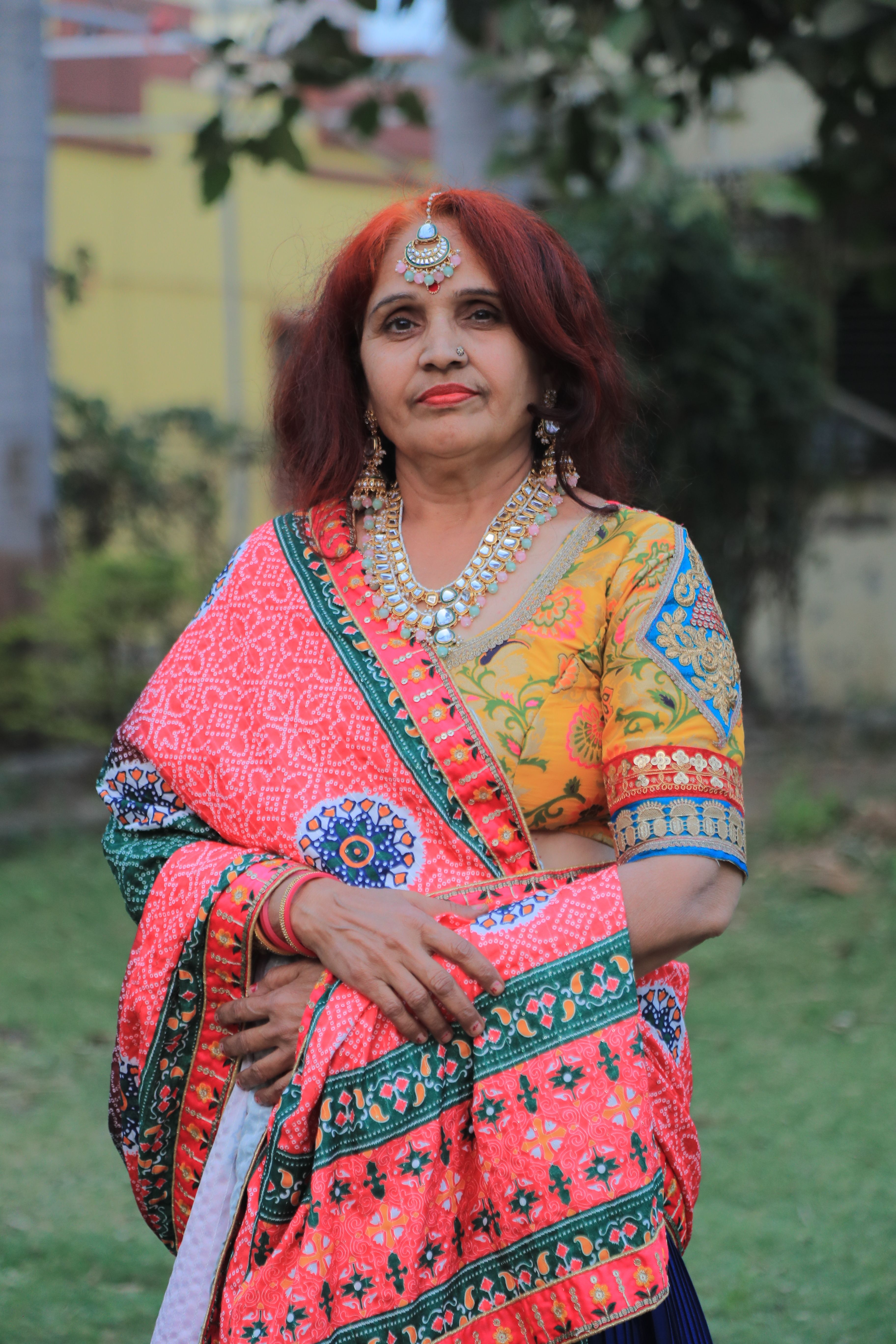 Portrait of a mature Indian woman wearing a vibrant sari and jewelry, outdoors