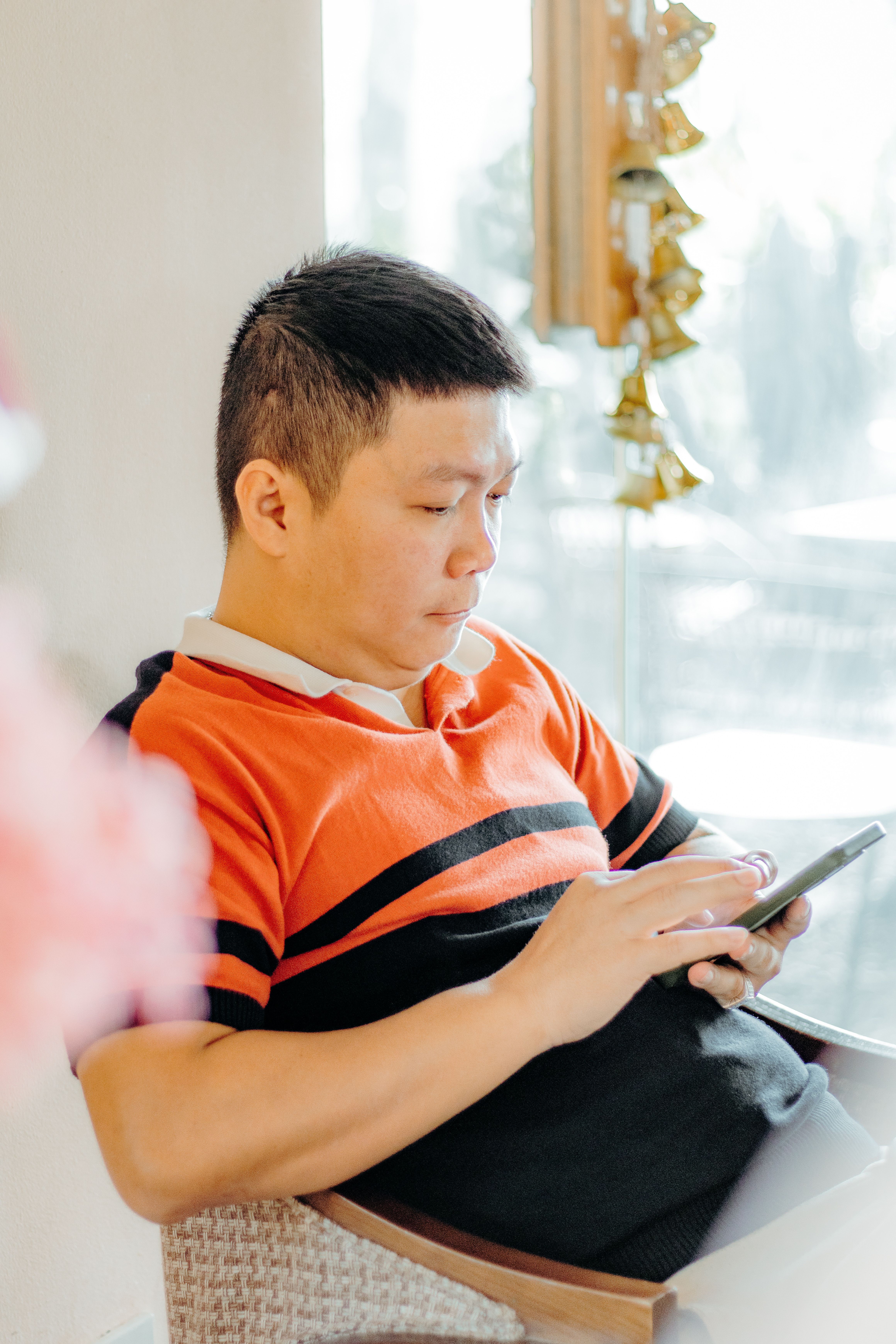 Man Using Smartphone in Bright Indoor Setting