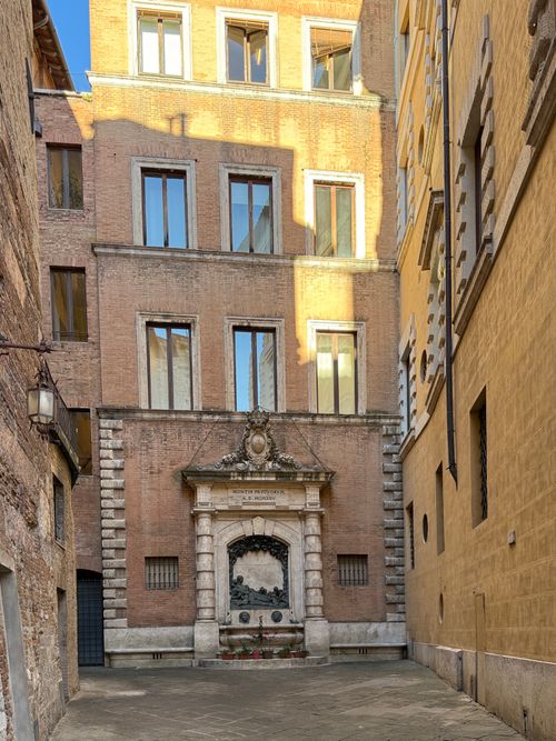 Free Charming alley with a historic fountain in Rome, Italy, under warm sunlight. Stock Photo