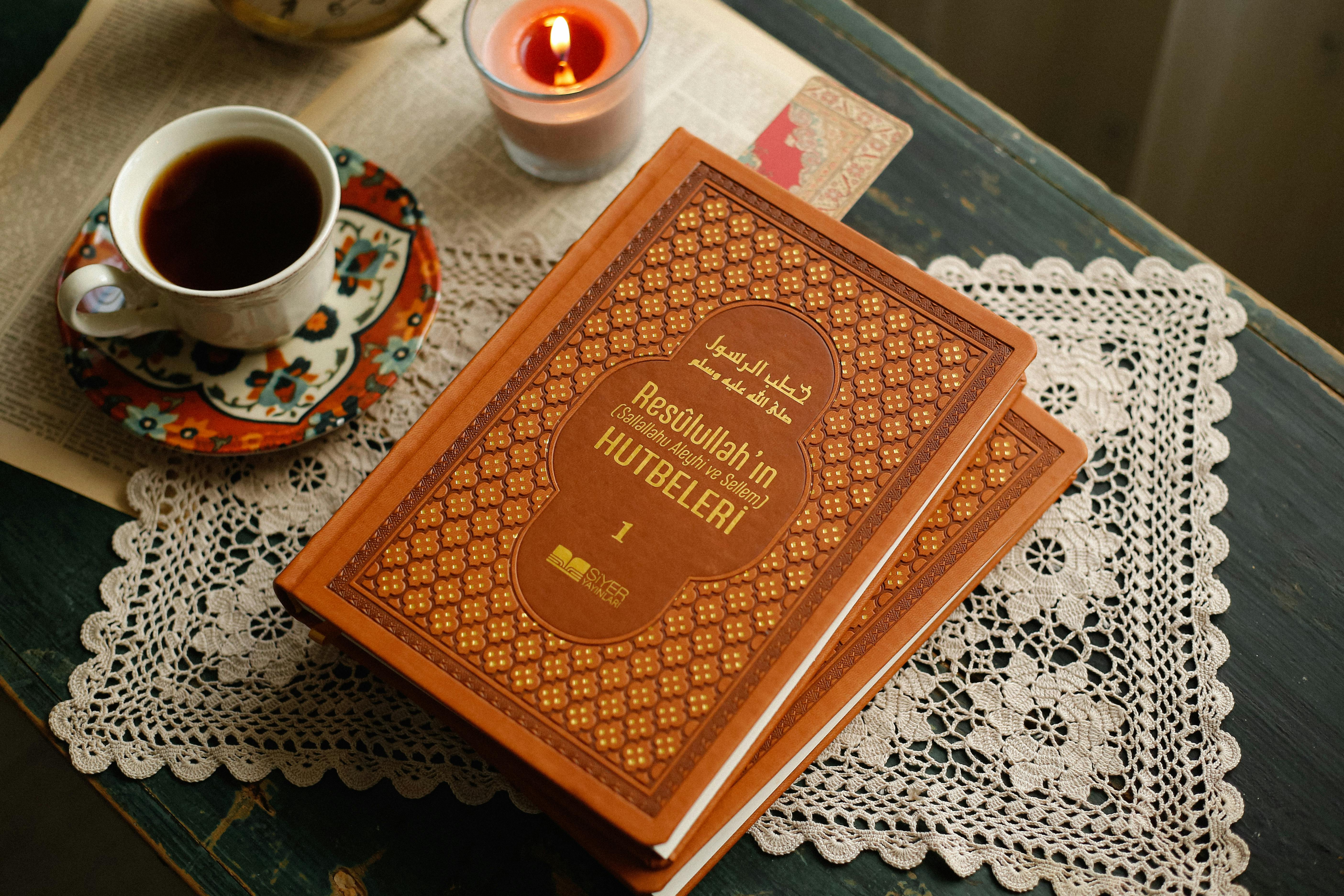 Warm and cozy setup of a book and tea cup on a lace tablecloth, perfect for relaxation and reading.