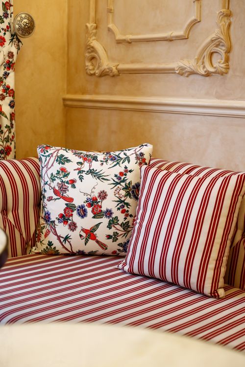 Free Sophisticated interior decor featuring floral and striped cushions on a classic couch. Stock Photo