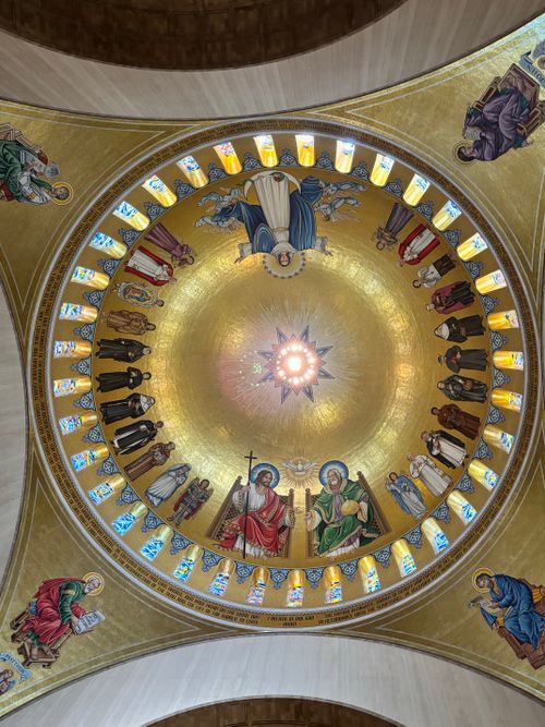 Free Intricate dome ceiling with religious paintings in a golden hue. Stock Photo