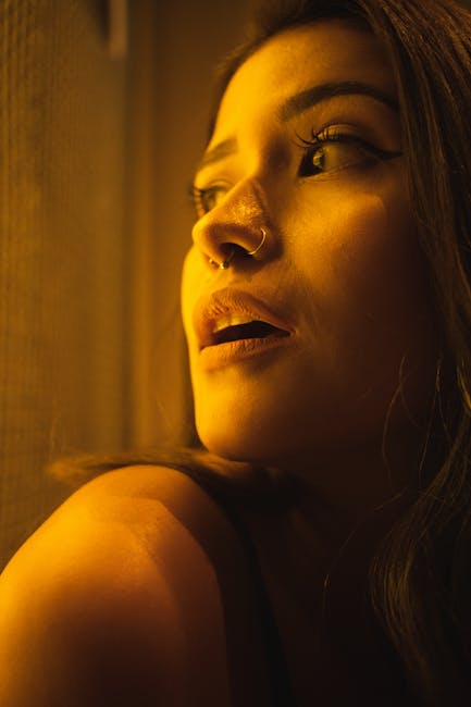 Portrait of a young woman in warm light, looking thoughtfully to the side.