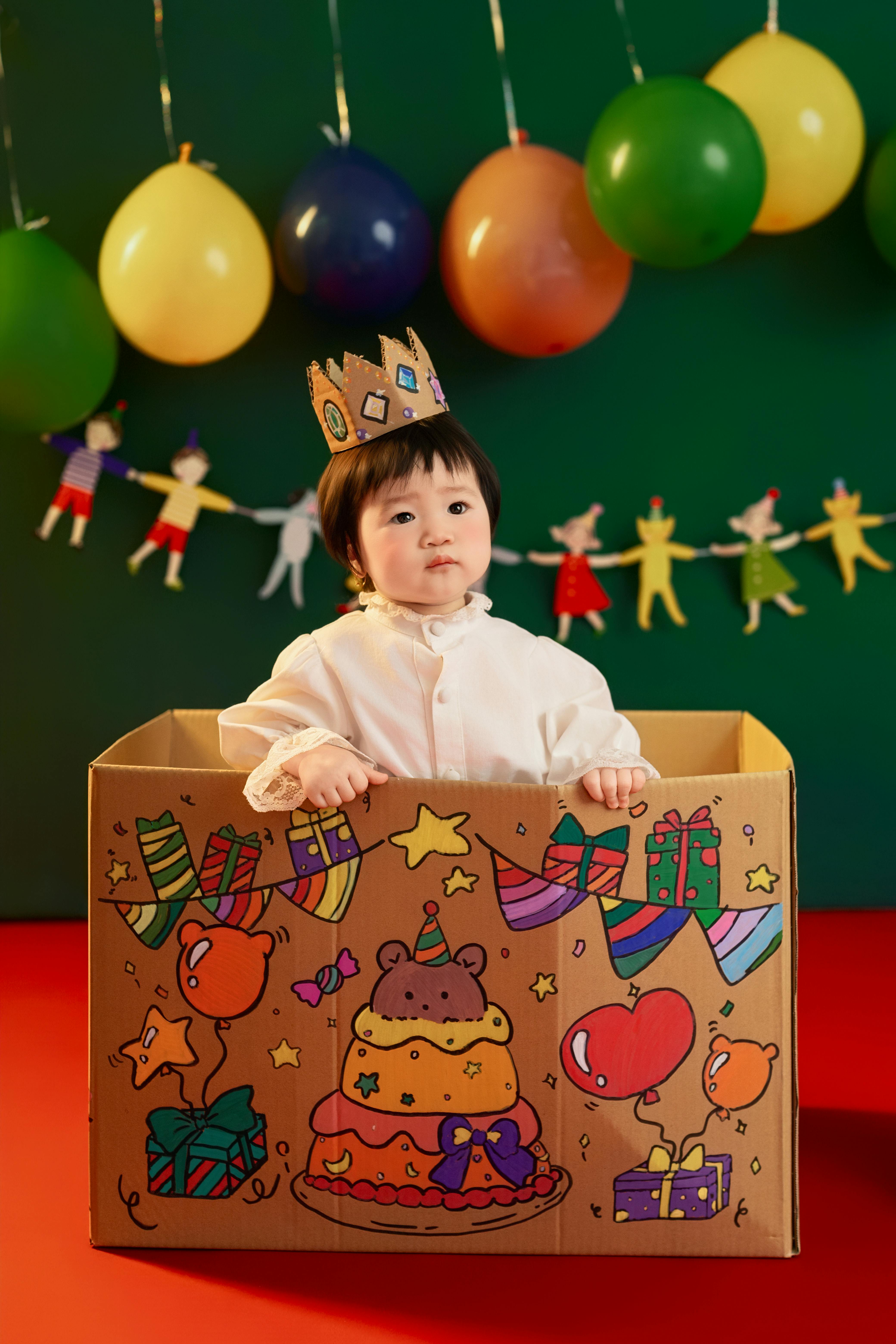 Child enjoying a colorful birthday celebration with balloons and decorations.