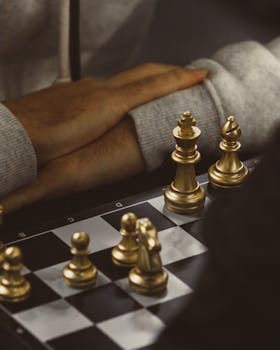 Intense chess game with gold pieces, showcasing strategic focus and concentration.