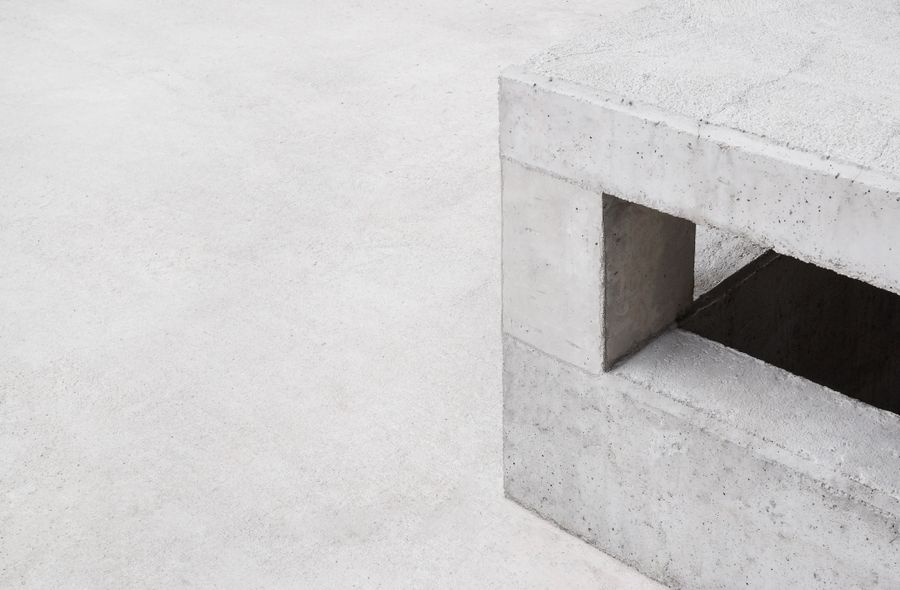 Minimalist concrete architecture with clean geometric lines and strong shadow, evoking Swiss precision