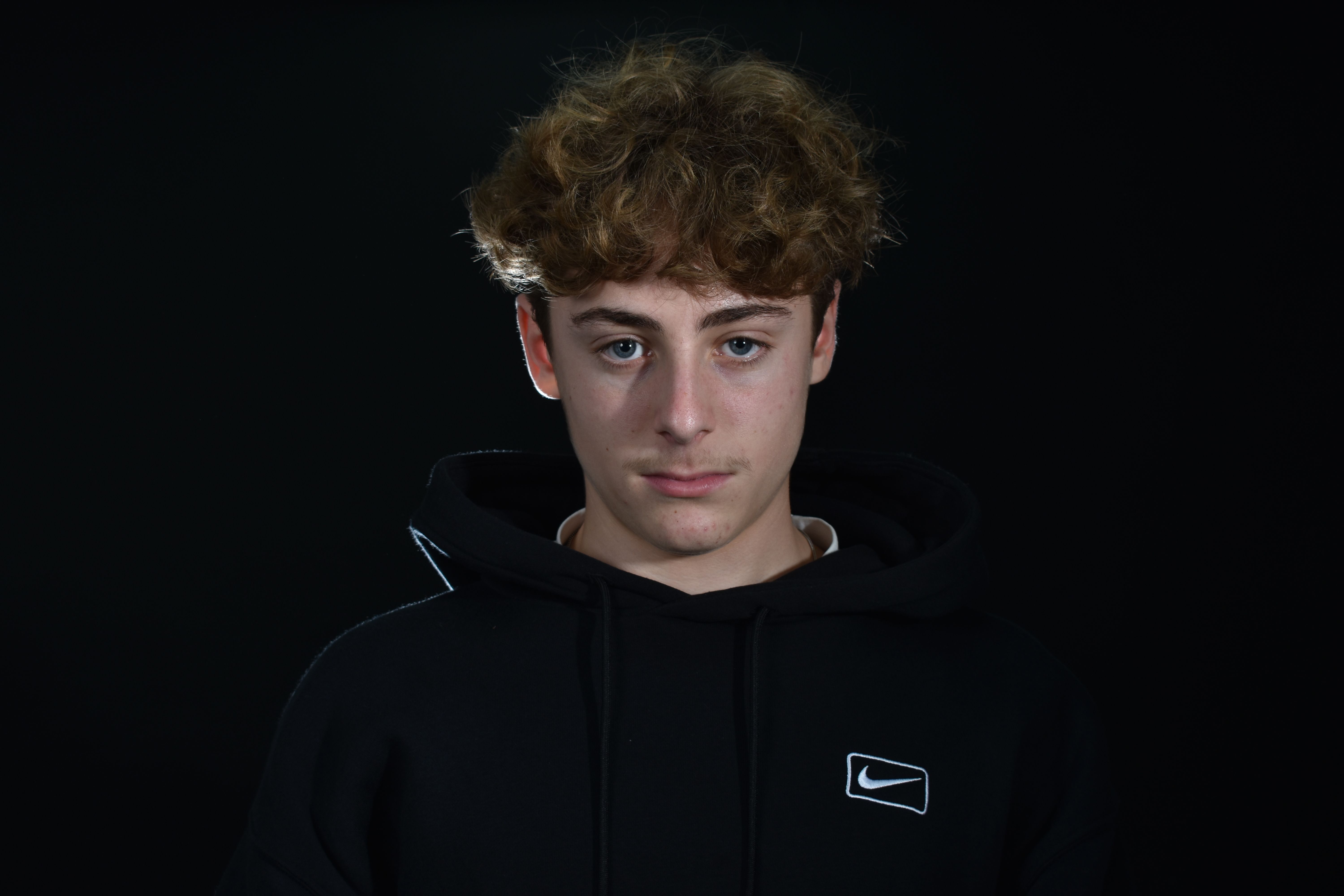 Portrait of Young Man in Black Hoodie on Black Background · Free Stock ...