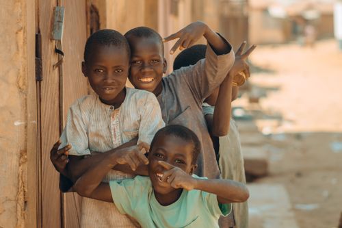 Free Four cheerful children pose and play on a sunny day in an African neighborhood. Stock Photo