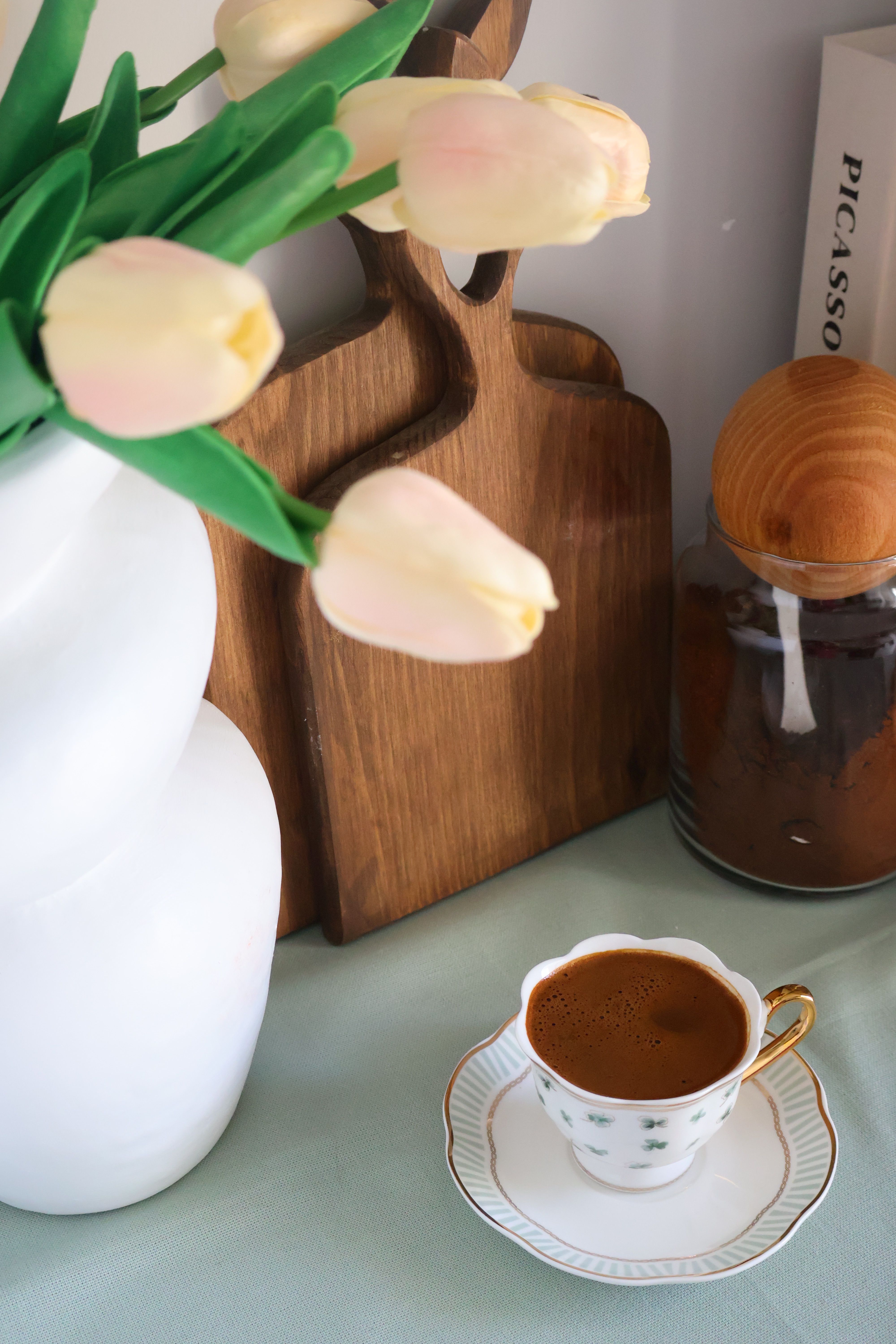 Small acacia cutting board leaned against the back of a coffee bar hutch shelf