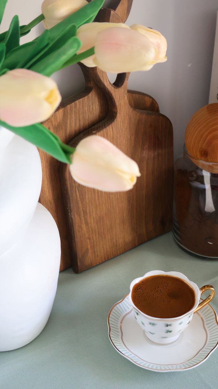 Small acacia cutting board leaned against the back of a coffee bar hutch shelf
