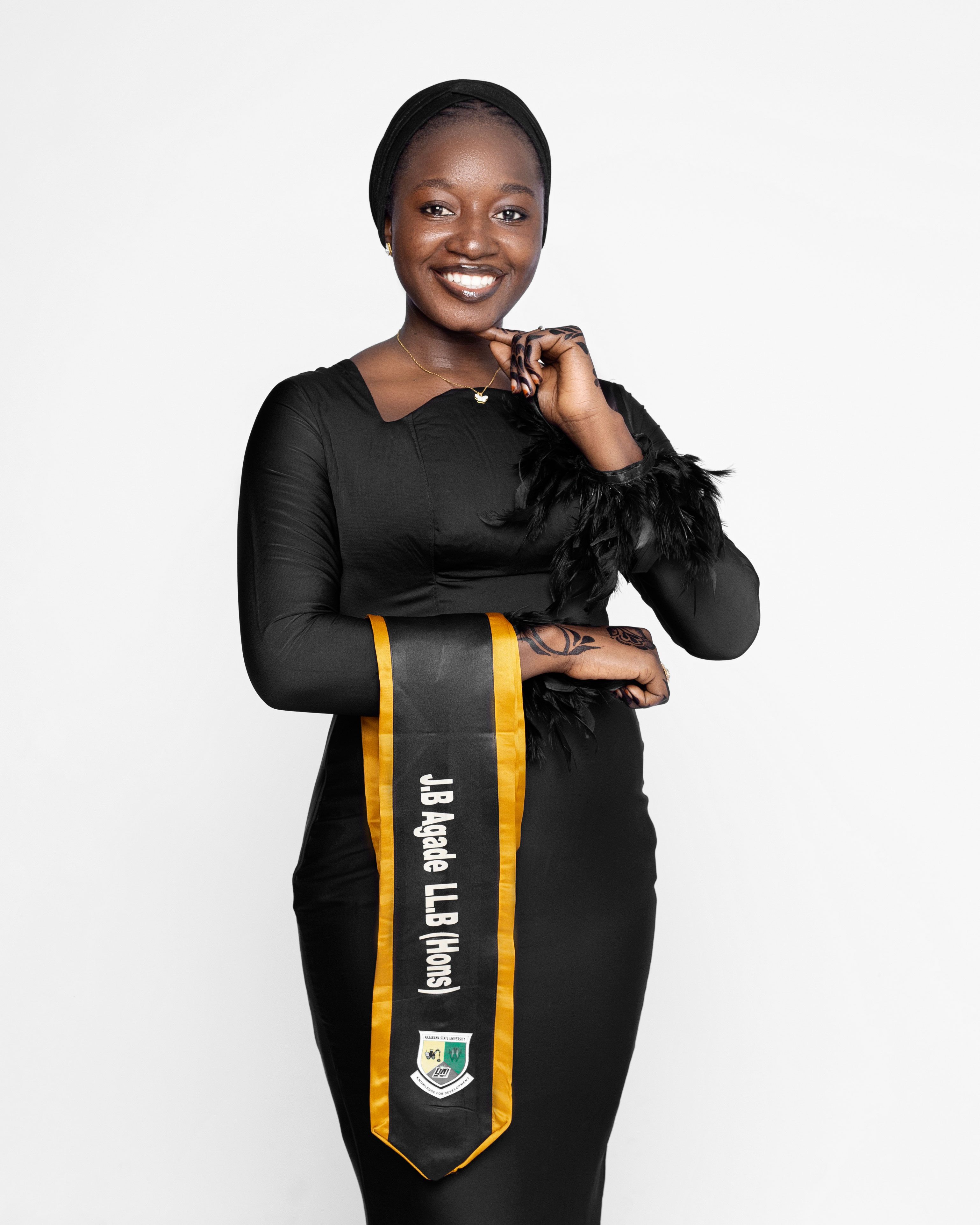 Smiling woman in academic robe celebrating graduation success.