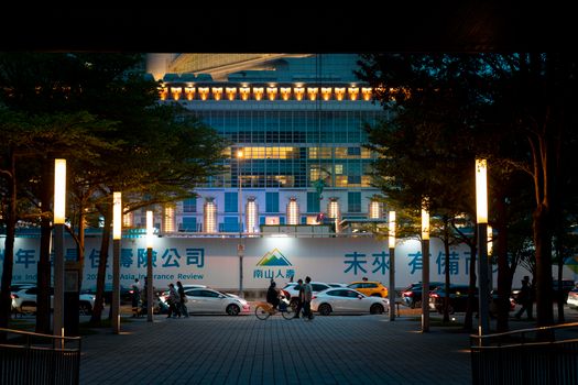 Vibrant night scene with illuminated modern architecture in Taipei, Taiwan, showcasing urban life.