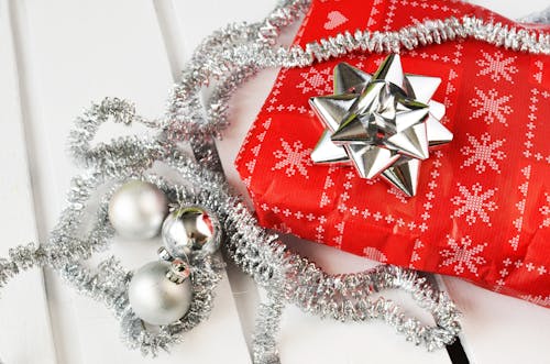 Several Silver Bauble Balls Beside Red Wrapper