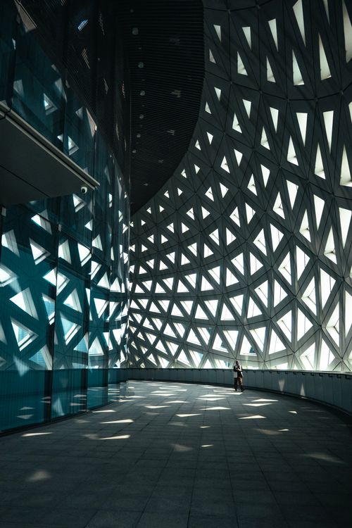 Free Dramatic interior view of modern architecture featuring intricate geometric patterns and ambient lighting. Stock Photo