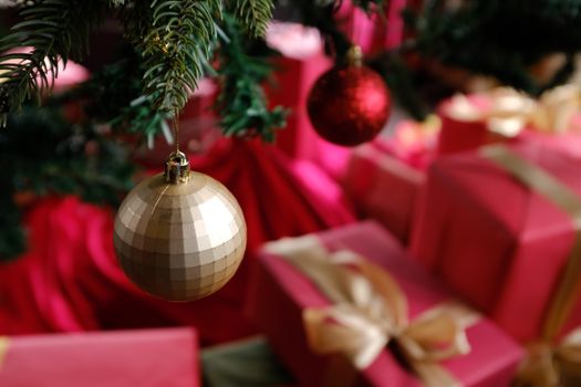 Christmas ornaments and gifts under a tree create a warm festive atmosphere., free online jigsaw puzzle on JigsawPuzzlesFreeOnline.org
