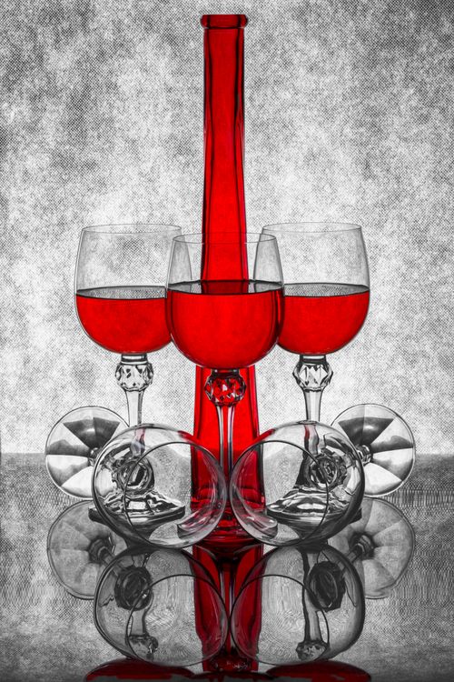 Free Artistic still life with red wine glasses and bottle on reflective surface creating symmetry. Stock Photo
