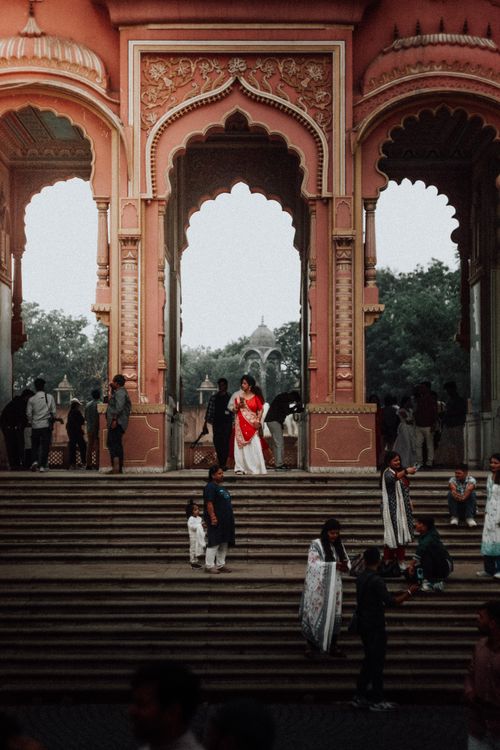 Free A vibrant scene of people in traditional attire at ornate historical arches. Stock Photo