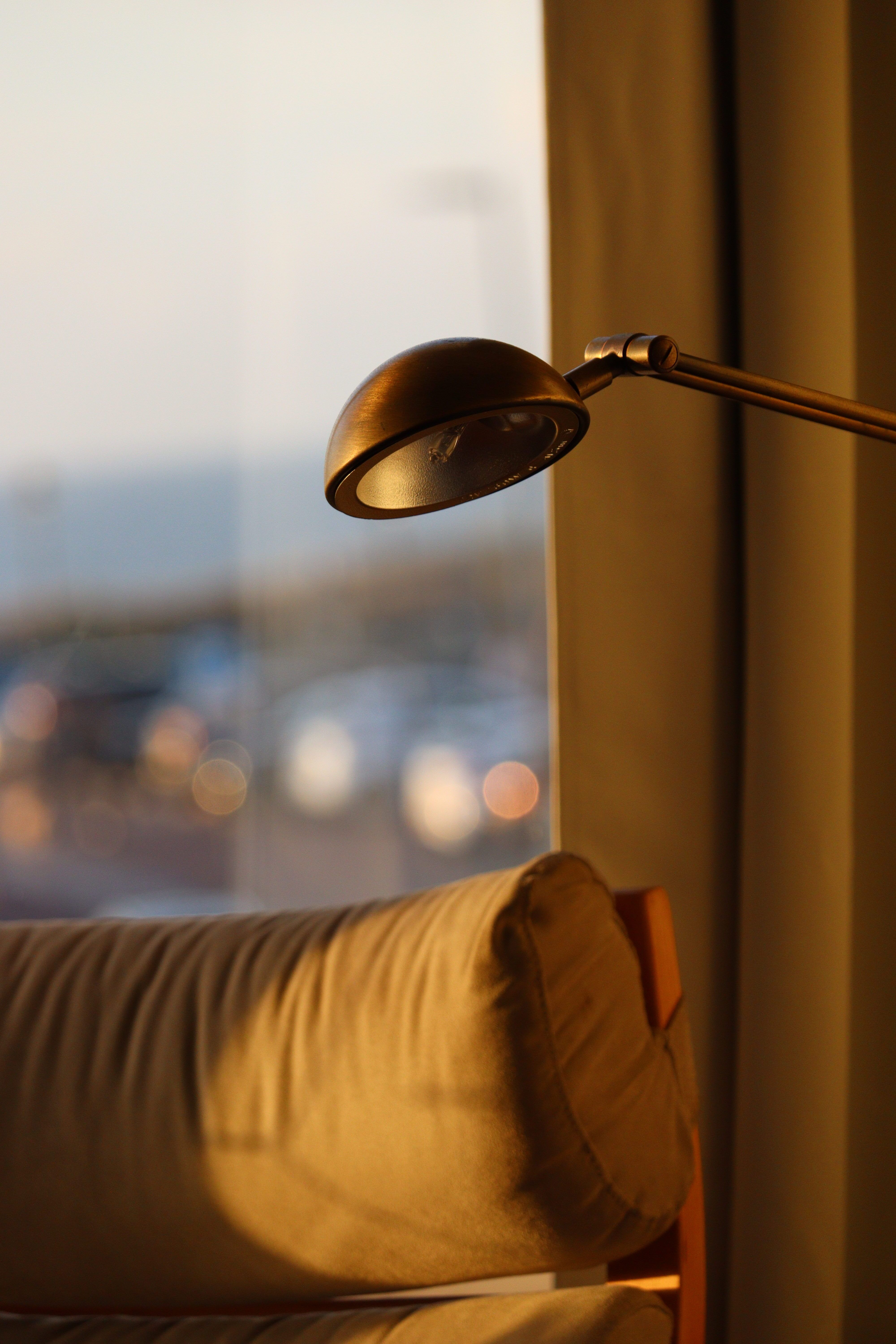 Ochre sofa beside a reading lamp at dusk, photo by Alina Zerkalii on Pexels
