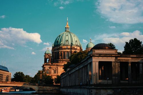 Free Capture the elegance of Berlin Cathedral with a serene river view during sunset. Stock Photo