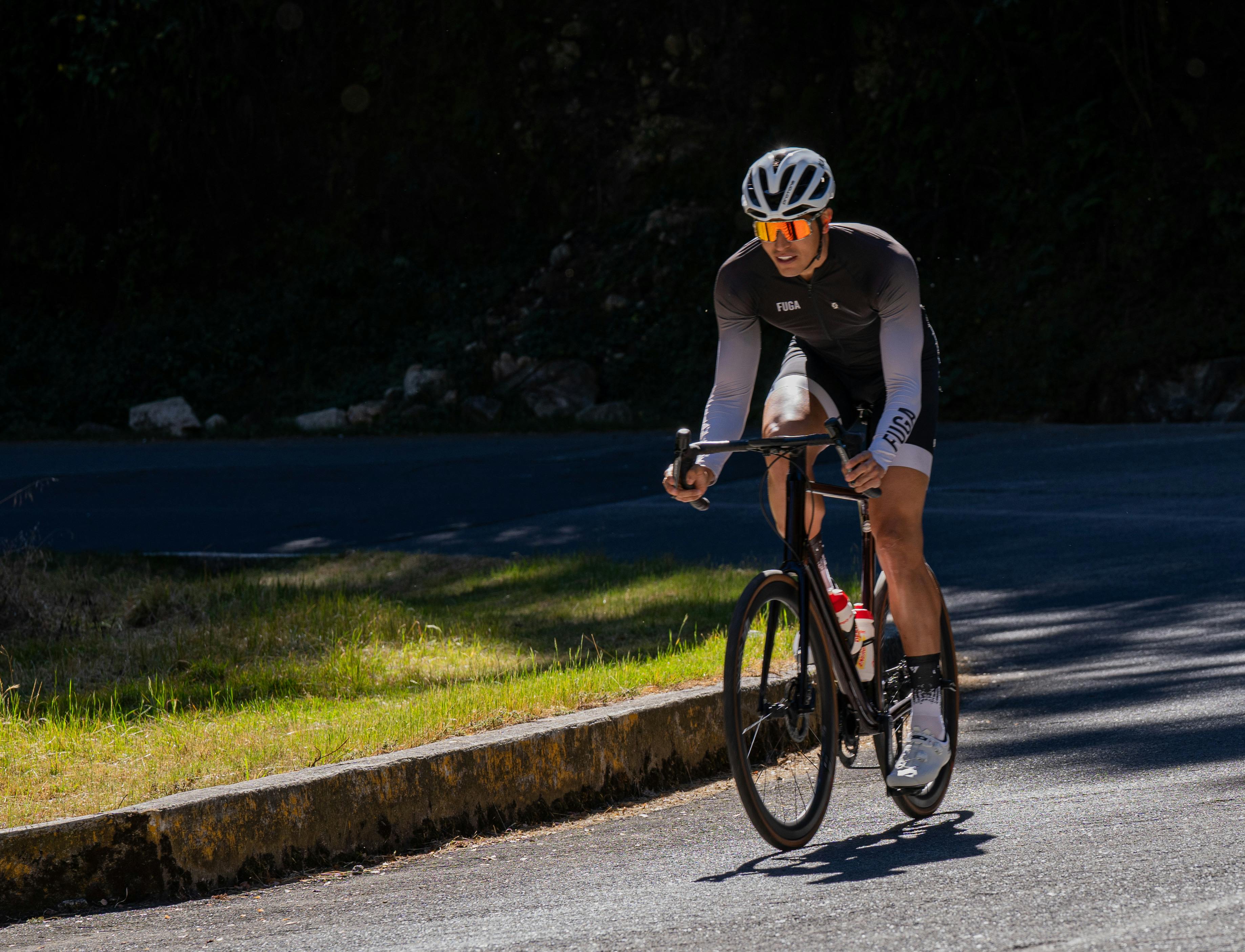 Professional cyclist riding on a sunny mountain road, embodying athletic determination.