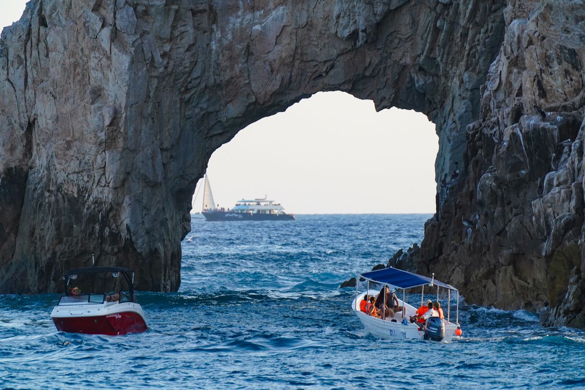 Scenic view of Arch of Cabo San Lucas with boats navigating the ocean waters.