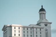Exterior of white building in classic style with domed tower on top against blue sky