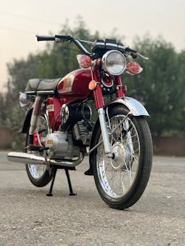 Classic red motorcycle parked outdoors in Punjab, showcasing vintage style.