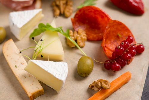 Free Artfully arranged cheese and charcuterie board with nuts, fruits, and cured meats. Stock Photo
