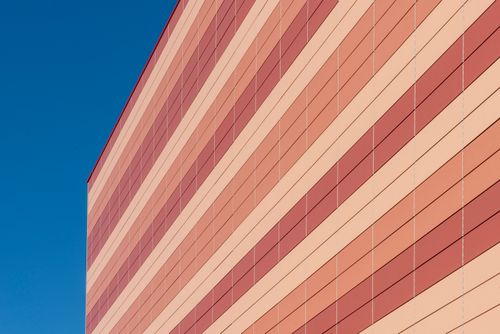 Free Abstract view of red and beige building facade against clear blue sky. Minimalist architecture concept. Stock Photo
