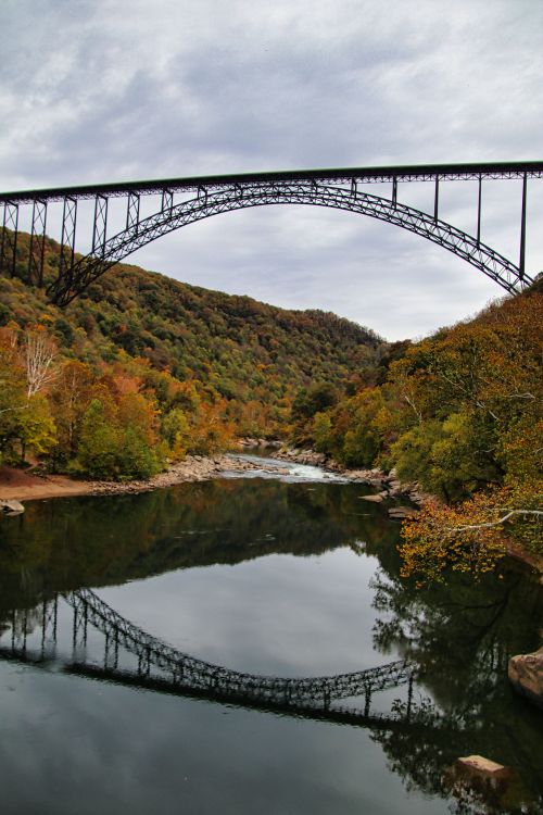Free Breathtaking autumn scene of New River Gorge Bridge with vibrant fall foliage and river reflection. Stock Photo