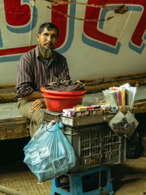 Free A street vendor in Dhaka, Bangladesh, selling various daily essentials in a vibrant urban setting. Stock Photo