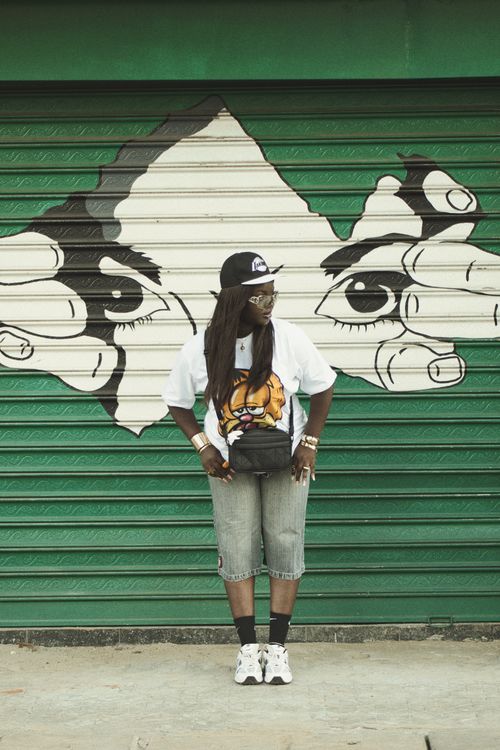 Free Person in casual outfit stands by a vibrant graffiti mural. Stock Photo
