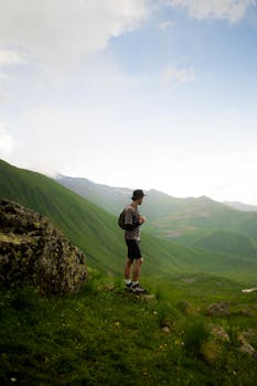 A lone hiker explores the stunning green hills of Georgia, embracing nature.
