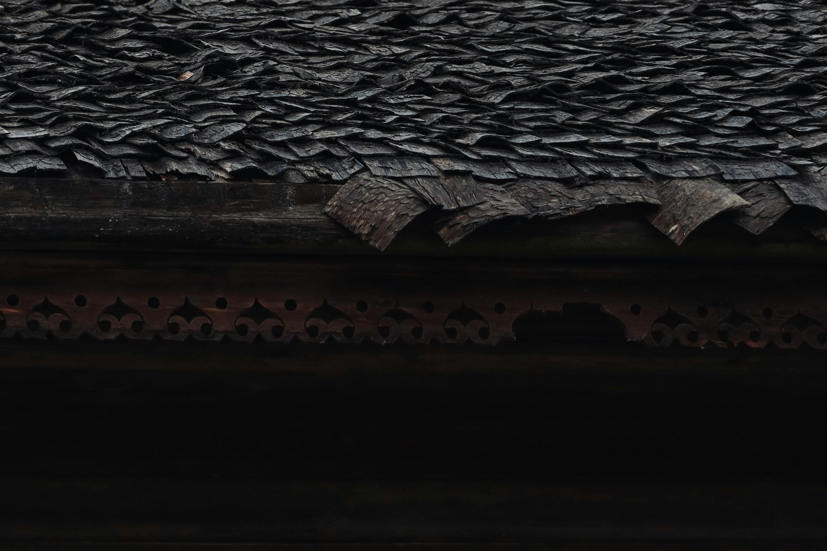 bezplatná Detail rustikální dřevěné střechy s texturovanými šindeli, které zdobí propracované detaily. Základová fotografie