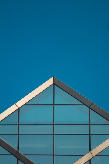Fotomural Fotografía minimalista de una moderna estructura de techo de cristal con un cielo azul despejado. Perfecta para temas de arquitectura y diseño.
