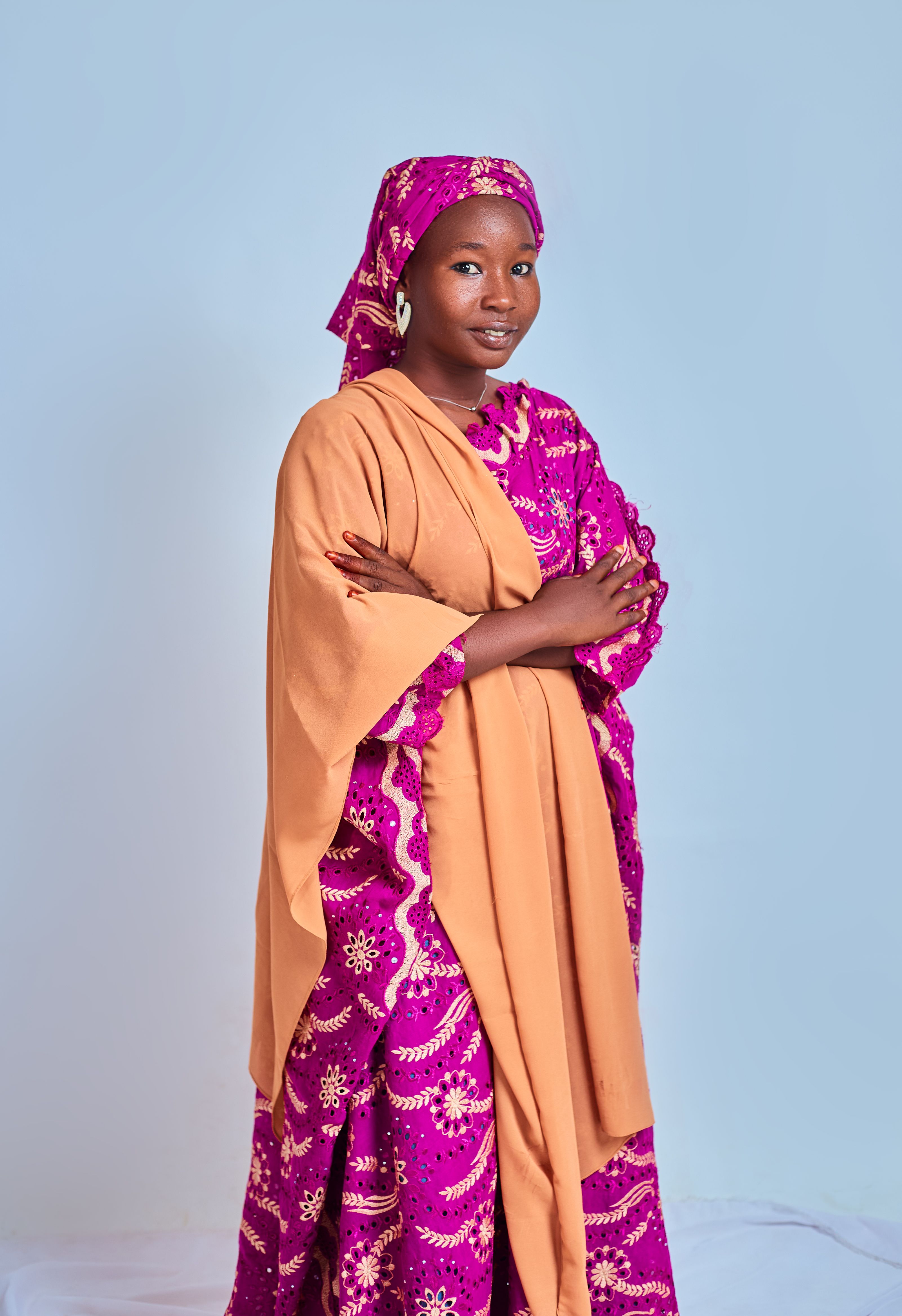 Stylish woman in vibrant traditional African attire posing confidently.