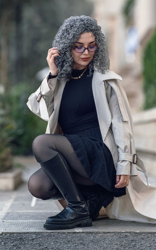 Free Stylish woman with gray curly hair poses confidently in a chic urban outfit. Stock Photo