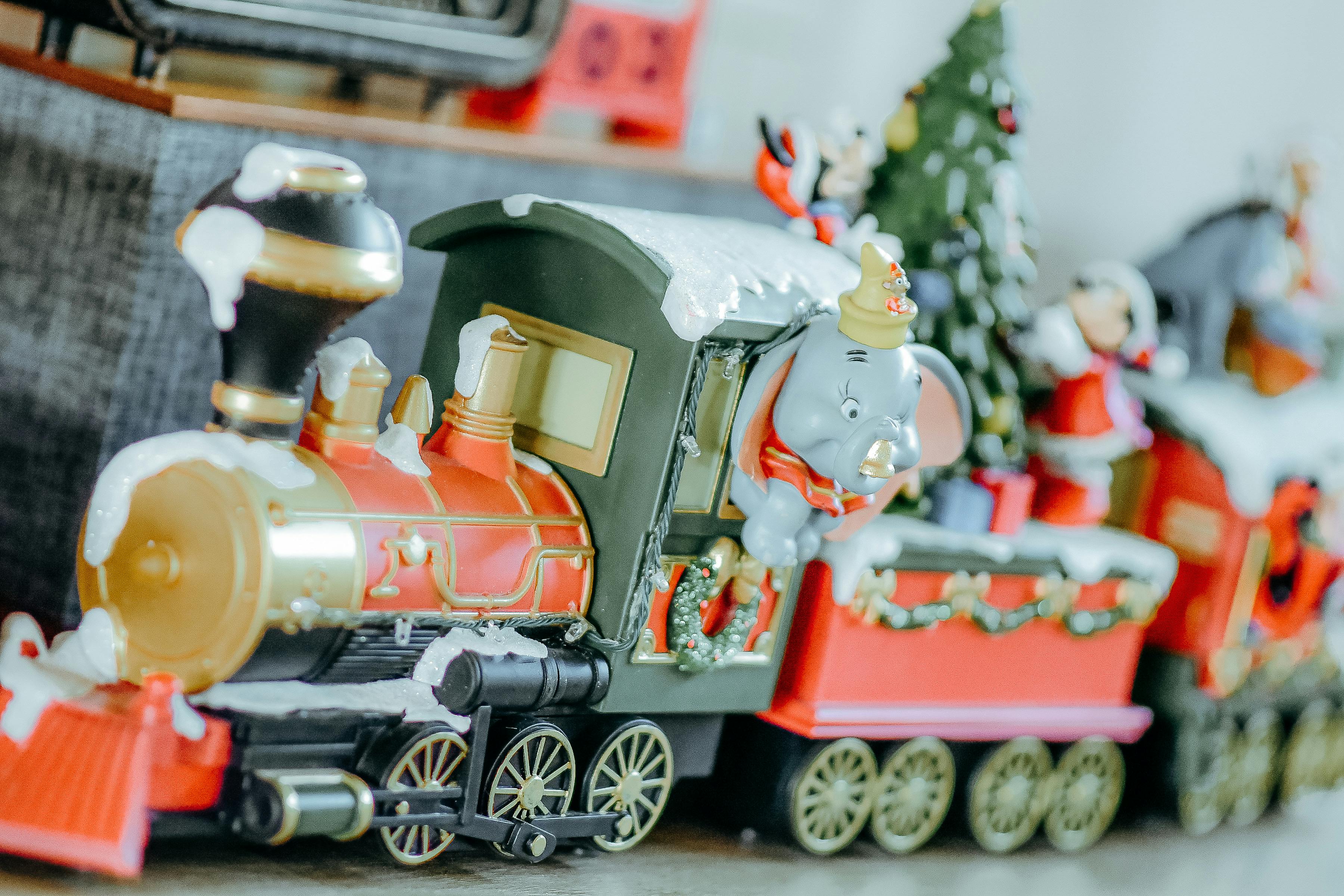 A colorful toy train adorned with festive decorations and holiday figures.